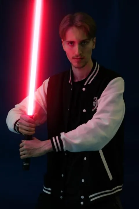 Portrait von Marco mit einem Lichtschwert in der Hand.
