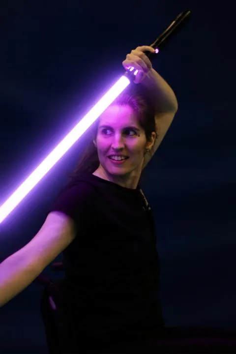 Portrait von Merit mit einem Lichtschwert in der Hand.