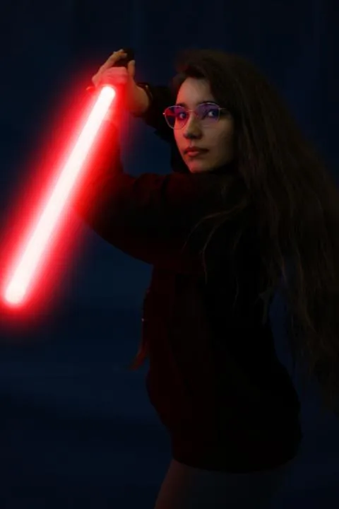 Portrait von Nathalie mit einem Lichtschwert in der Hand.